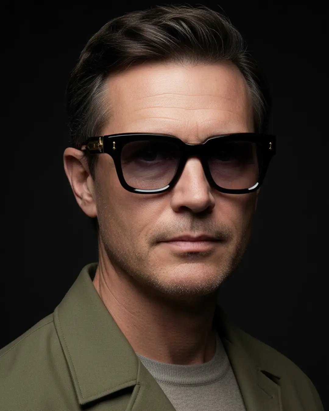 Agbassio The Philosopher black acetate sunglasses worn with a refined olive jacket